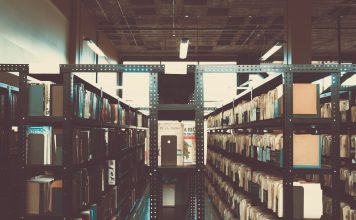 Jersey City Library Staff Air Complaints as Director Retires Bookshelves in a library with a vintage tone in San José, Costa Rica.