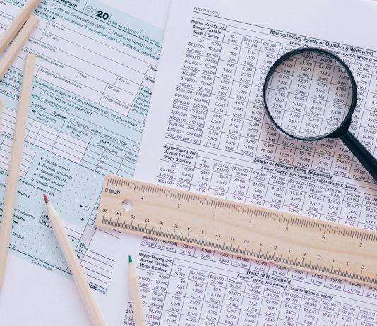 Jersey City’s 15% Tax Hike Firm, State Says A high angle view showing IRS tax forms with pencils, ruler, and magnifying glass for financial planning.