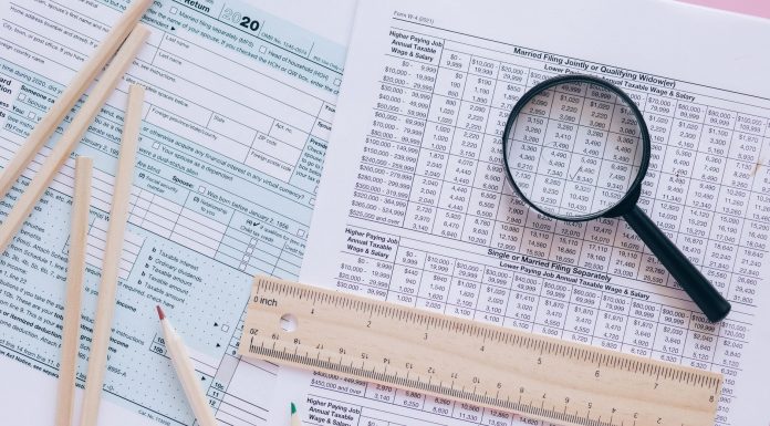 Jersey City’s 15% Tax Hike Firm, State Says A high angle view showing IRS tax forms with pencils, ruler, and magnifying glass for financial planning.