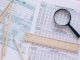 Jersey City’s 15% Tax Hike Firm, State Says A high angle view showing IRS tax forms with pencils, ruler, and magnifying glass for financial planning.