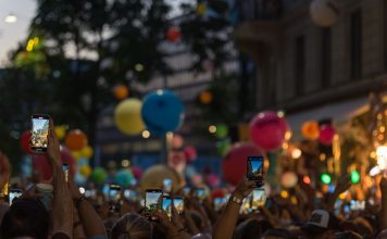 Jersey City Tower Wi-Fi Collapses Under Event Crowds A lively crowd captures a festive street scene filled with colorful balloons and vibrant energy.