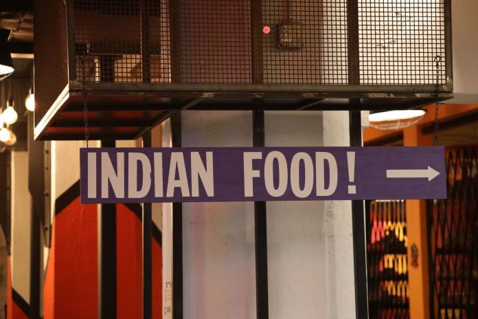 kati-roll-company-plans-second-jersey-spot-in-hobo Indoor setting with a large sign reading 'Indian Food' pointing directionally.