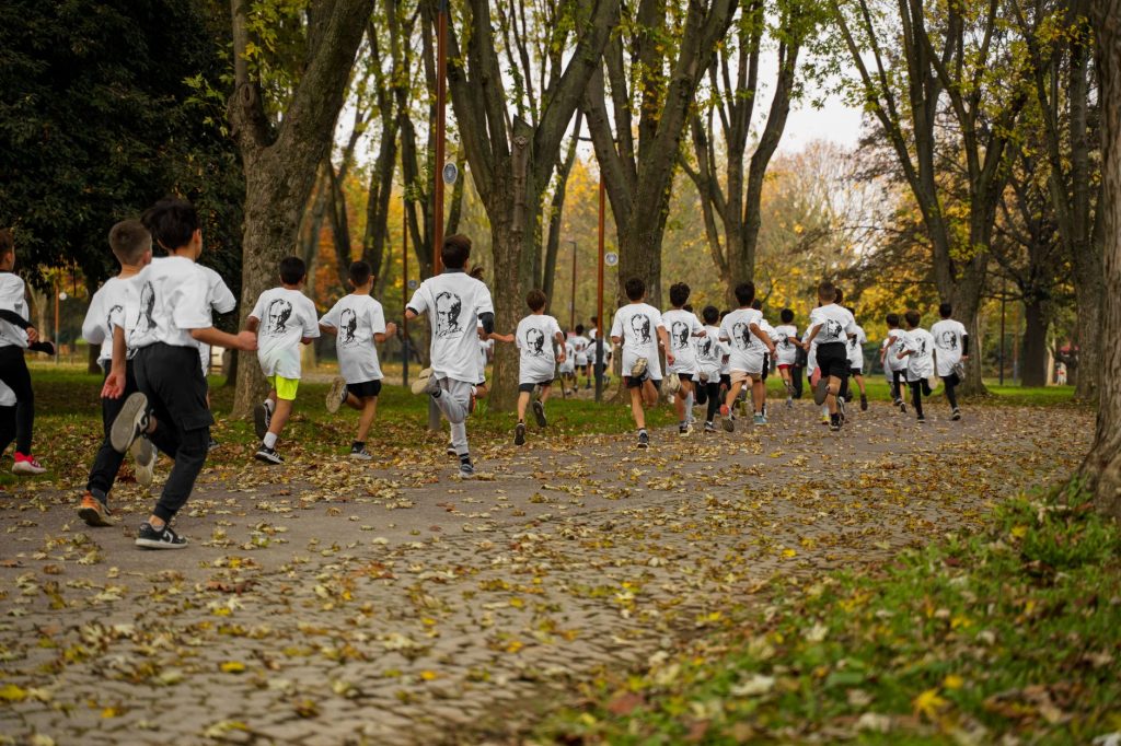 A group of kids participating in a running event in a leafy park in Bursa, Türkiye.