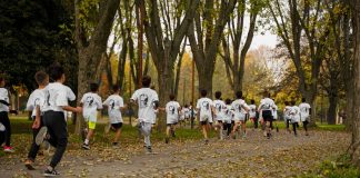 A group of kids participating in a running event in a leafy park in Bursa, Türkiye.
