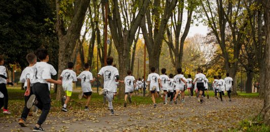A group of kids participating in a running event in a leafy park in Bursa, Türkiye.