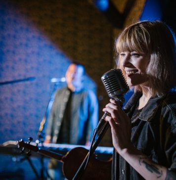 Live Music in August: Pet Shop’s Tenth Birthday, Summerfest, More Smiling caucasian woman singing with vintage microphone during live music performance.