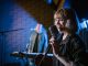 Live Music in August: Pet Shop’s Tenth Birthday, Summerfest, More Smiling caucasian woman singing with vintage microphone during live music performance.