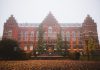 ÚLTIMA HORA: 9 pueblos escalofriantes de la Costa Este para visitar este otoño Historic Lund University Library facade with autumn foliage and fog, Sweden.
