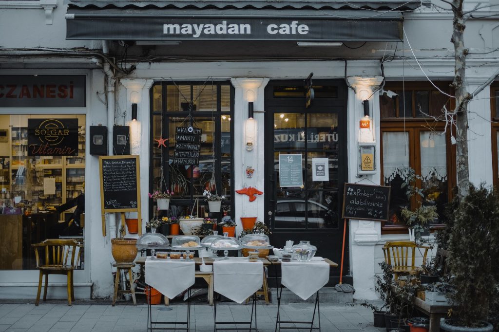 An inviting outdoor café showcasing local food, menu boards, and charming decorations in a quaint neighborhood setting.