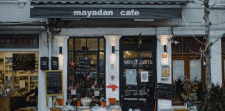 An inviting outdoor café showcasing local food, menu boards, and charming decorations in a quaint neighborhood setting.