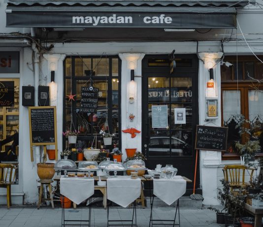 An inviting outdoor café showcasing local food, menu boards, and charming decorations in a quaint neighborhood setting.