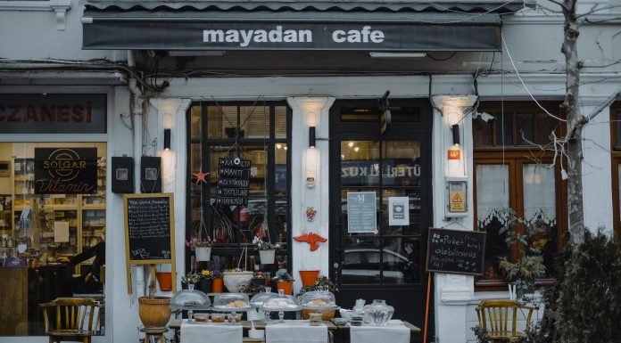 An inviting outdoor café showcasing local food, menu boards, and charming decorations in a quaint neighborhood setting.