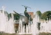 A striking bronze statue at the Sandefjord Whalers Monument fountain in Norway's urban park.