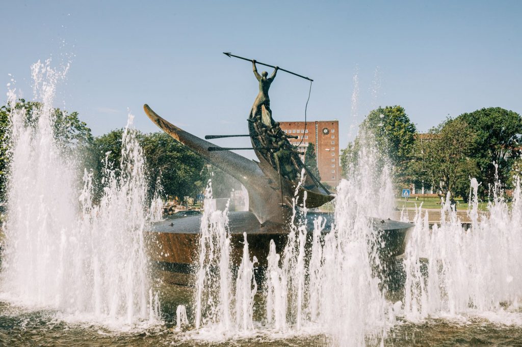 A striking bronze statue at the Sandefjord Whalers Monument fountain in Norway's urban park.