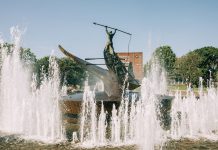 A striking bronze statue at the Sandefjord Whalers Monument fountain in Norway's urban park.