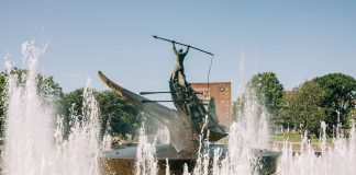 A striking bronze statue at the Sandefjord Whalers Monument fountain in Norway's urban park.