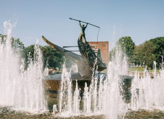 A striking bronze statue at the Sandefjord Whalers Monument fountain in Norway's urban park.