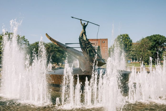 A striking bronze statue at the Sandefjord Whalers Monument fountain in Norway's urban park.