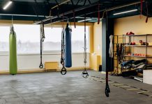 A modern gym with equipment, punching bags, and open space for workouts.
