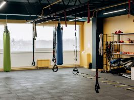 A modern gym with equipment, punching bags, and open space for workouts.
