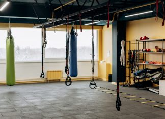 A modern gym with equipment, punching bags, and open space for workouts.