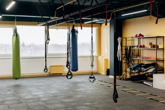 ltima-hora-city-fitness-abrir-dos-gimnasios-en-ho A modern gym with equipment, punching bags, and open space for workouts.