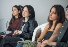 Focused individuals attending an indoor seminar, showcasing engagement and learning.