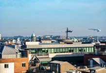 A vibrant view of Dublin's cityscape featuring construction cranes and iconic architecture under a clear blue sky.