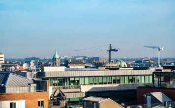 ÚLTIMA HORA: Ex parque corporativo en Berkeley Heights se transforma en distrito de $500 millones A vibrant view of Dublin's cityscape featuring construction cranes and iconic architecture under a clear blue sky.