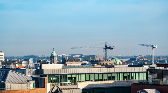 ÚLTIMA HORA: Ex parque corporativo en Berkeley Heights se transforma en distrito de $500 millones A vibrant view of Dublin's cityscape featuring construction cranes and iconic architecture under a clear blue sky.