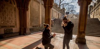 A couple shares a marriage proposal moment under Bethesda Terrace, Central Park.