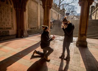 A couple shares a marriage proposal moment under Bethesda Terrace, Central Park.