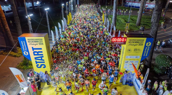Vivid start of a midnight marathon in Ho Chi Minh City with a large crowd.