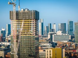 Aerial view of modern skyscrapers in Manchester with ongoing construction highlighting urban growth.