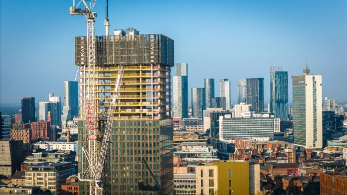 Aerial view of modern skyscrapers in Manchester with ongoing construction highlighting urban growth.