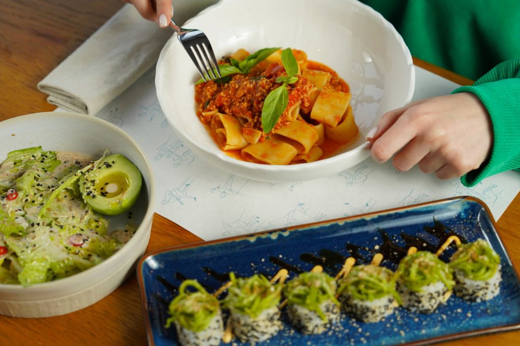 Delicious pasta with fresh basil and avocado salad served in an inviting setting. Perfect for health-conscious diners.