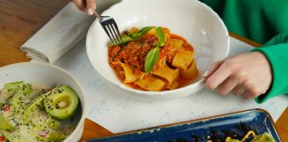 Delicious pasta with fresh basil and avocado salad served in an inviting setting. Perfect for health-conscious diners.