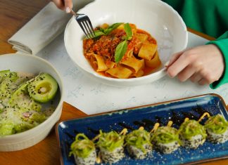 Delicious pasta with fresh basil and avocado salad served in an inviting setting. Perfect for health-conscious diners.