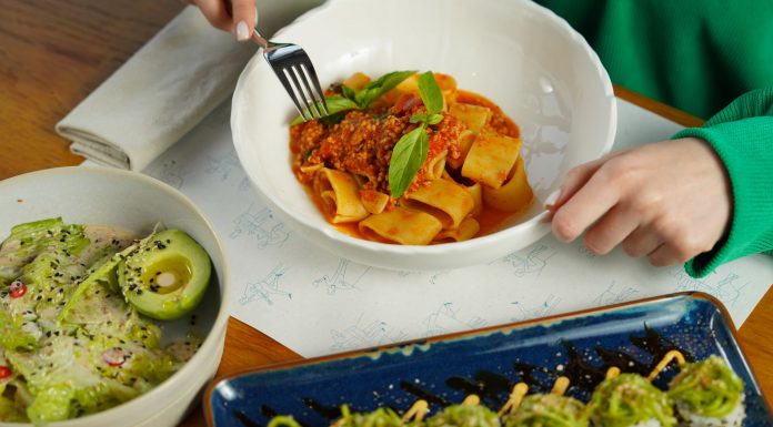 Delicious pasta with fresh basil and avocado salad served in an inviting setting. Perfect for health-conscious diners.