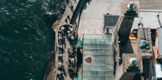 Top-down view of a riverside restaurant in Porto, Portugal, with people dining outdoors.