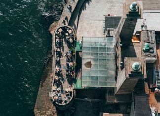 Top-down view of a riverside restaurant in Porto, Portugal, with people dining outdoors.