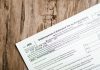 Close-up of a corporate tax form on a textured wooden surface, highlighting document details.
