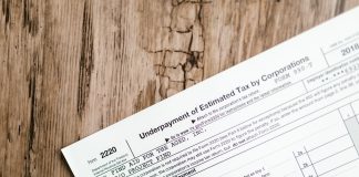 Close-up of a corporate tax form on a textured wooden surface, highlighting document details.