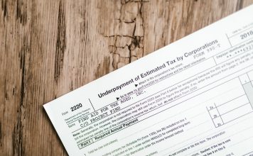 Close-up of a corporate tax form on a textured wooden surface, highlighting document details.