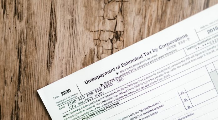 Close-up of a corporate tax form on a textured wooden surface, highlighting document details.