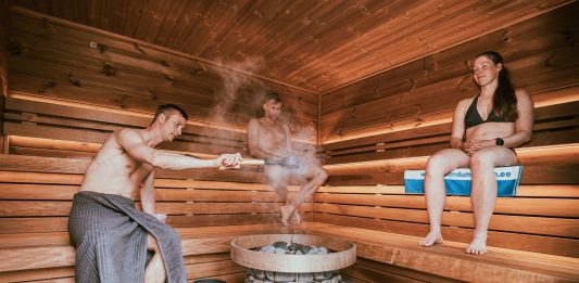 Three people enjoying a steamy sauna session, embracing wellness and relaxation.