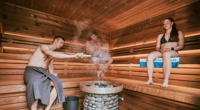 Three people enjoying a steamy sauna session, embracing wellness and relaxation.