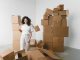ÚLTIMA HORA: Washington General Store se muda a nuevo local en Hoboken Young female with curly hair between piles and flying cardboard containers after moving into house on light background