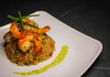 Savory prawn fried rice garnished with chives on a stylish white plate, capturing gourmet cuisine.