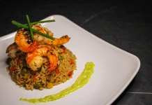 Savory prawn fried rice garnished with chives on a stylish white plate, capturing gourmet cuisine.